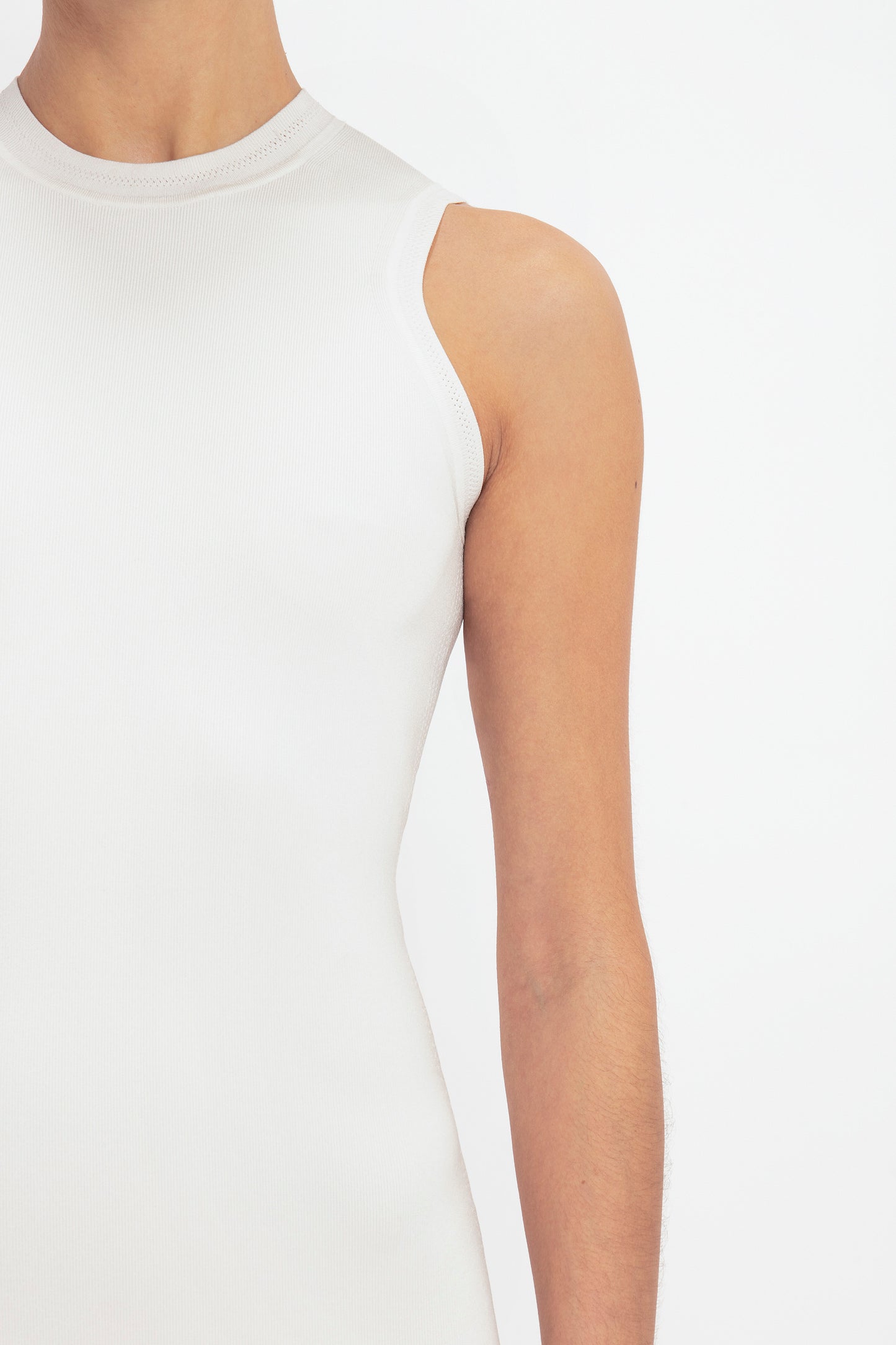 Individual sporting the VB Body Mini Dress in White by Victoria Beckham, captured from neck to mid-arm against a neutral backdrop.