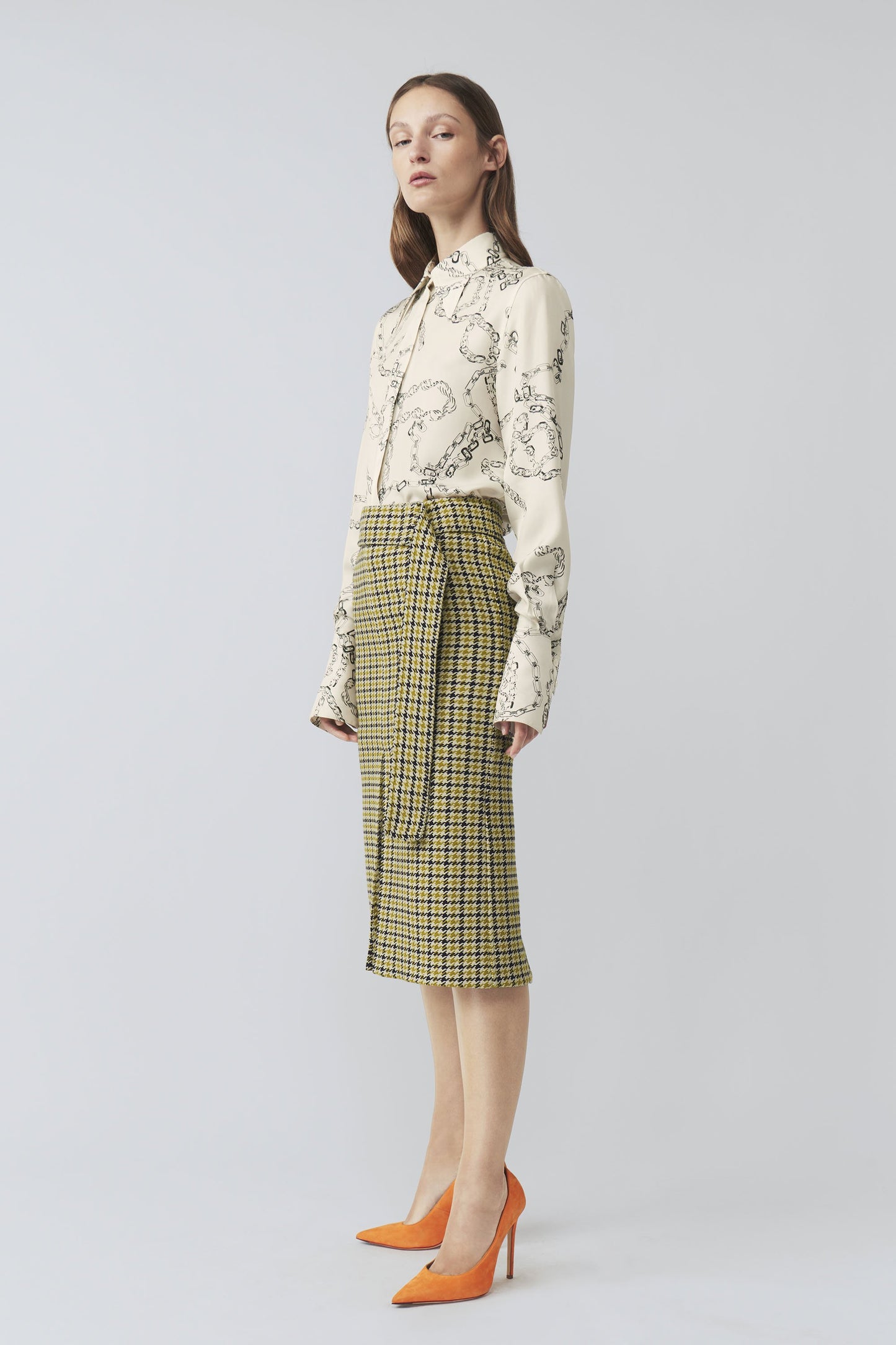 The model is wearing a yellow checkered 70's Collar Shirt and orange Victoria Beckham heels.