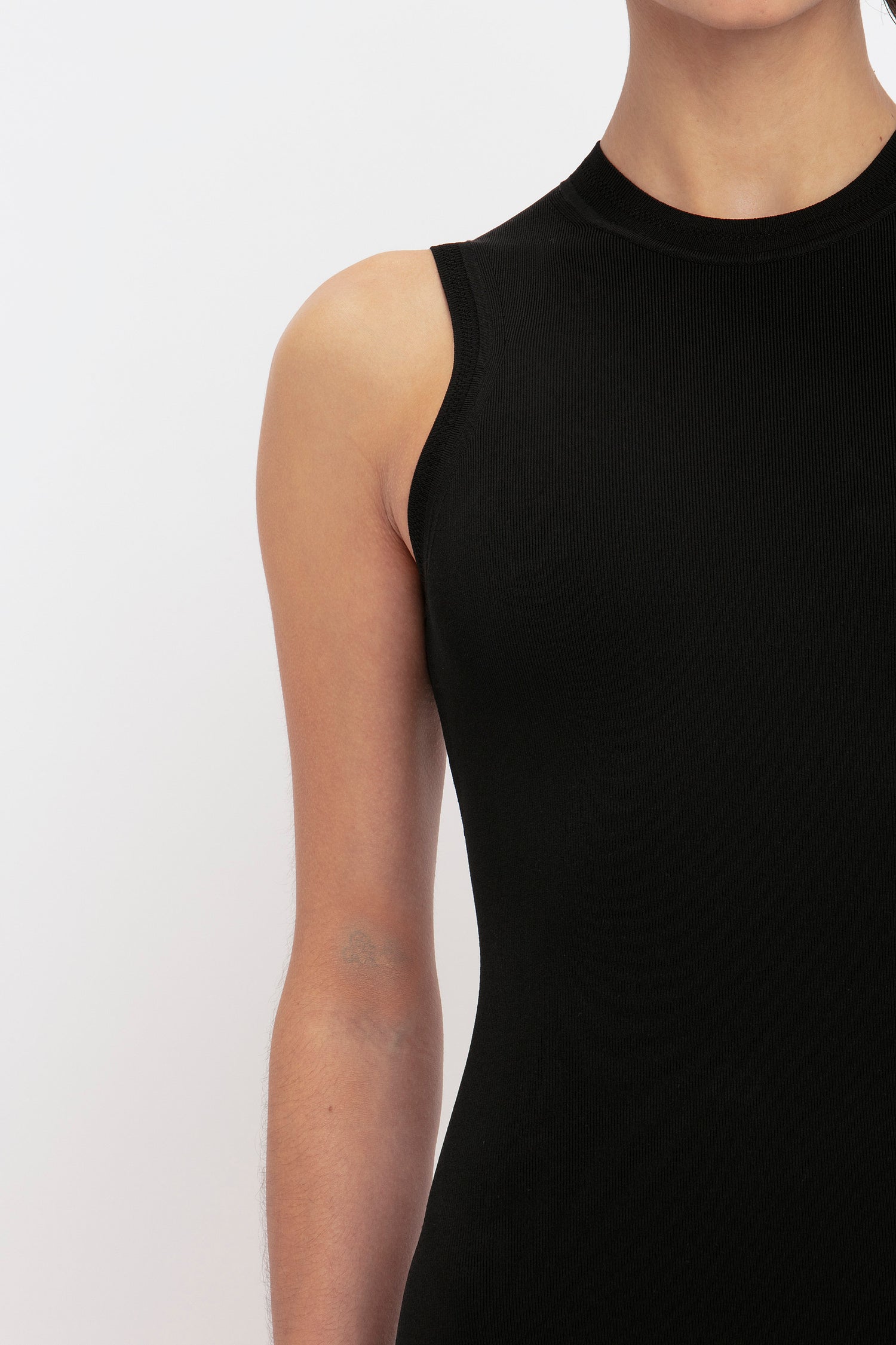 Person wearing the VB Body Mini Dress in Black by Victoria Beckham, visible from chest to neck against a light background.