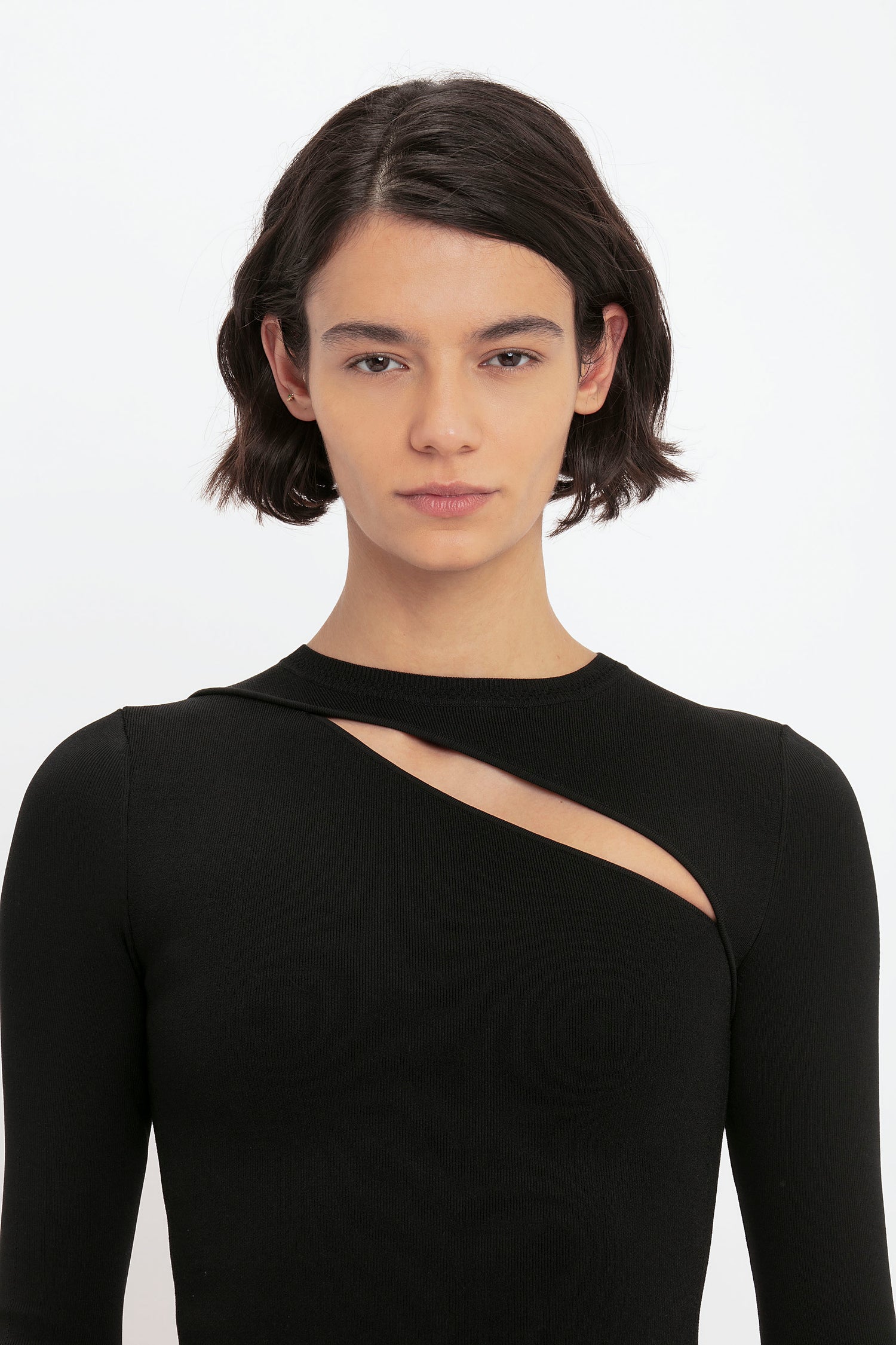 A person with short brown hair wearing the Victoria Beckham VB Body Front Slash Crew Neck Top in Black.
