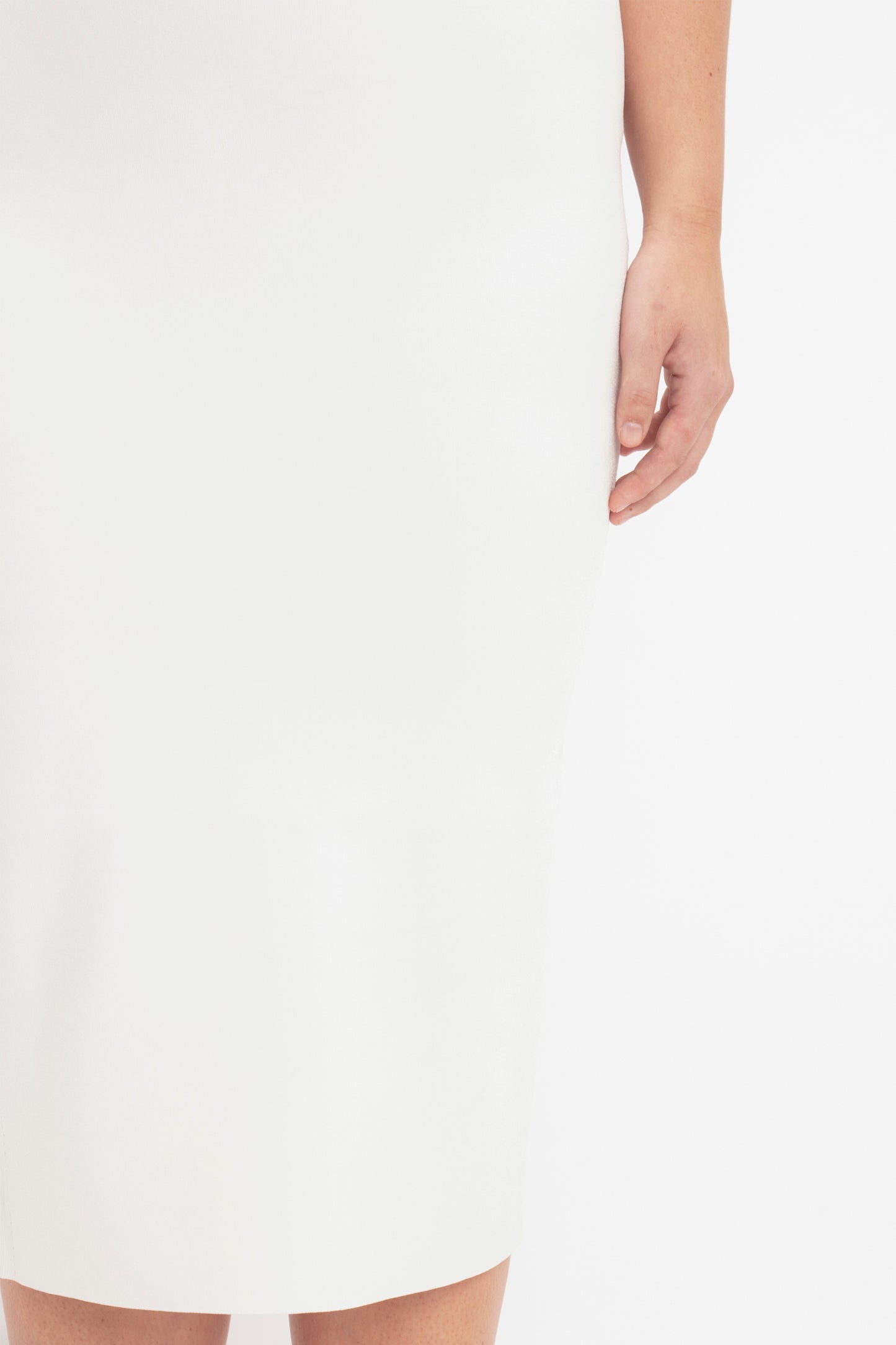 Close-up photo showcasing someone wearing the VB Body Slash Front Midi Dress in White by Victoria Beckham. Only one arm and the lower torso are visible.