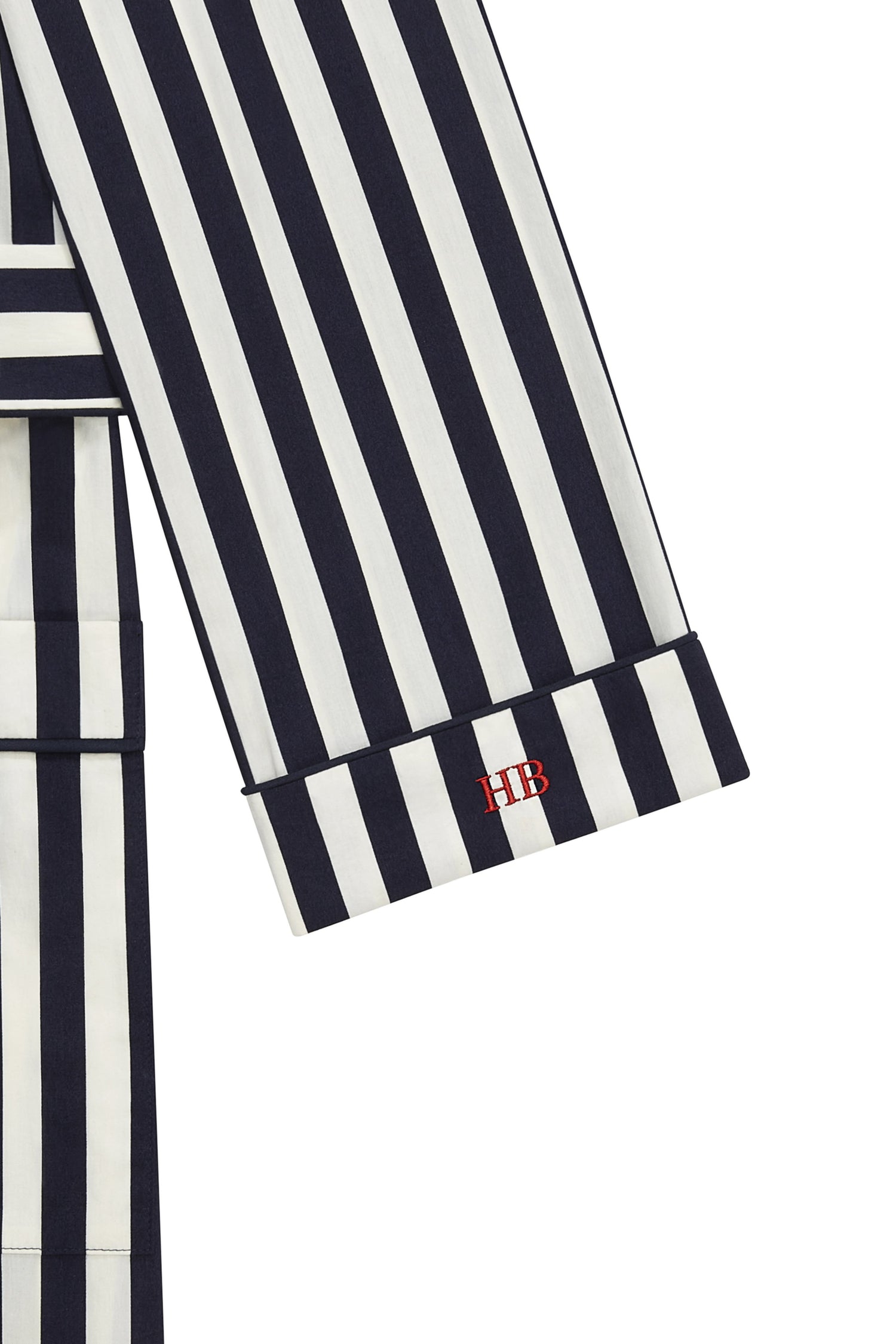 Close-up of black and white striped fabric with a red "VB" monogram on the sleeve cuff, offering a touch of personalisation from Victoria Beckham.