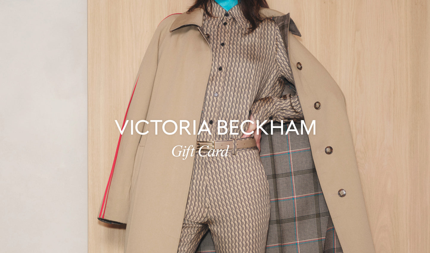 Image of a person wearing a beige patterned suit, partially covered by a beige coat. The text reads "Victoria Beckham VB Gift Card," perfect for that last-minute present with convenient email delivery.