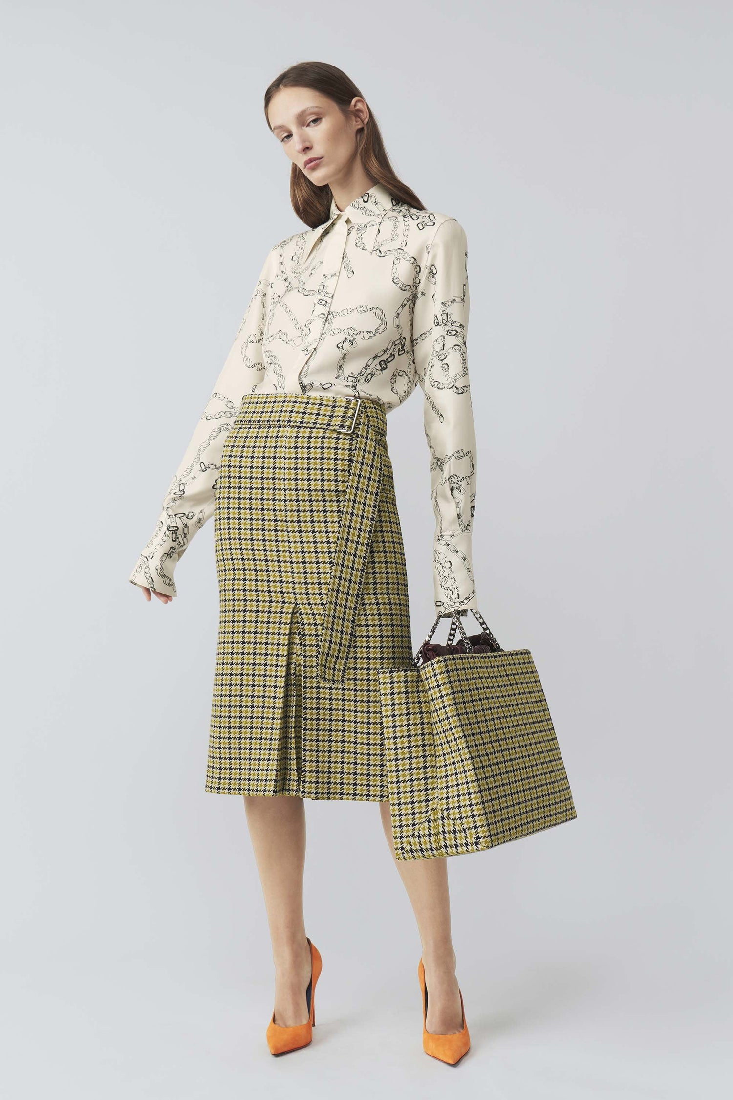The model is wearing a yellow gingham skirt and a white Victoria Beckham 70's Collar Shirt with a point collar.