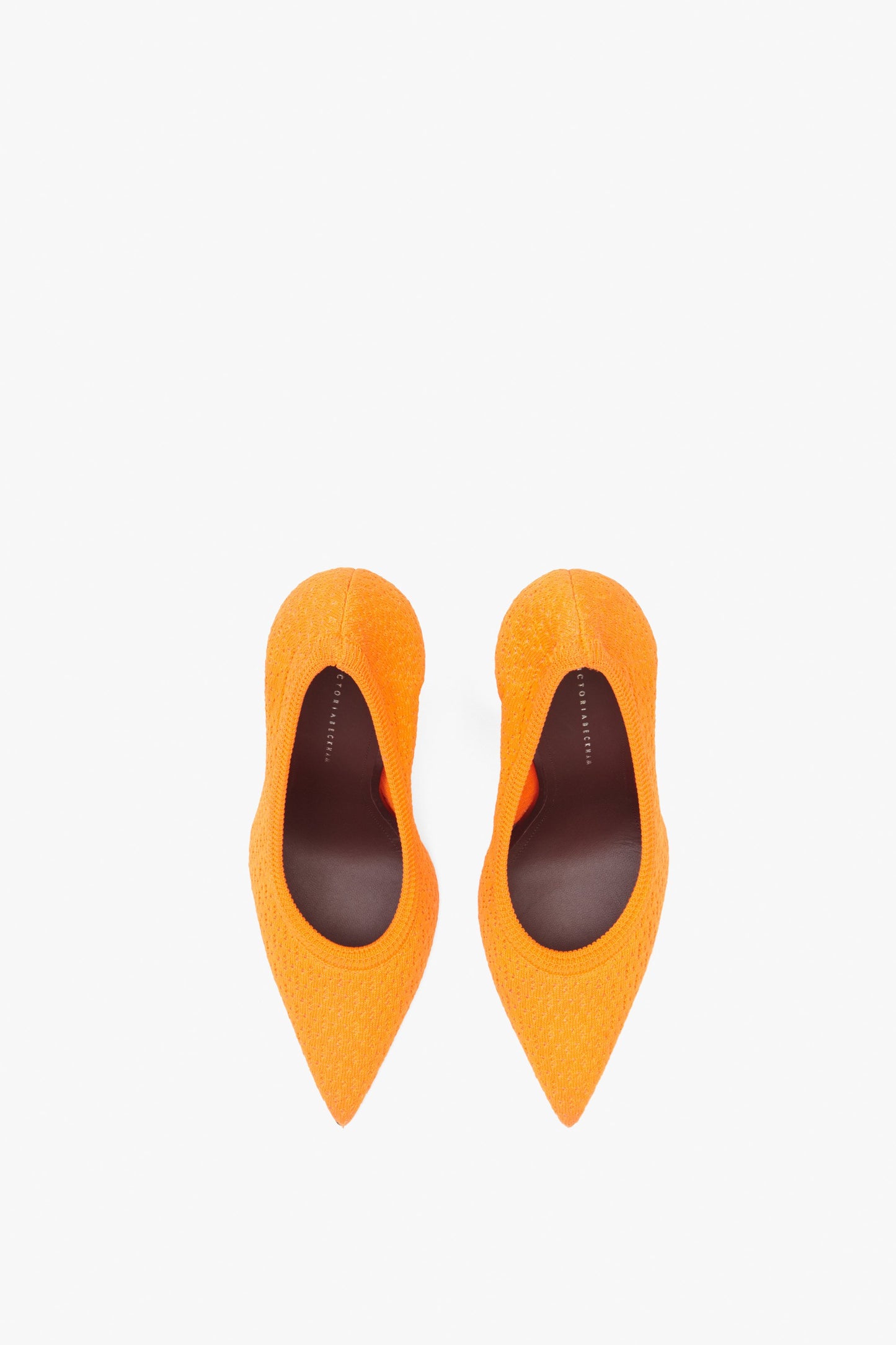 Top view of the Christy 115MM Knit Pumps by Victoria Beckham, featuring pointed toes and stiletto heels in orange, against a plain white background.