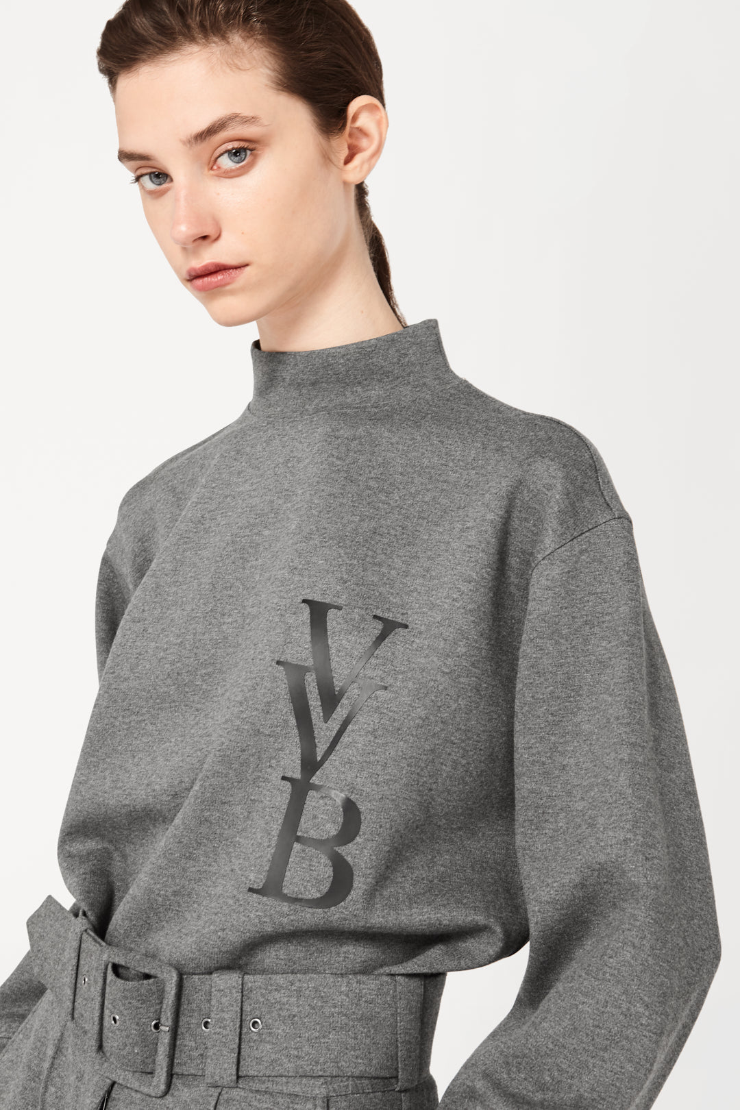The model is wearing a grey sweatshirt with the Victoria Beckham logo on it made of smooth ponti melange jersey.