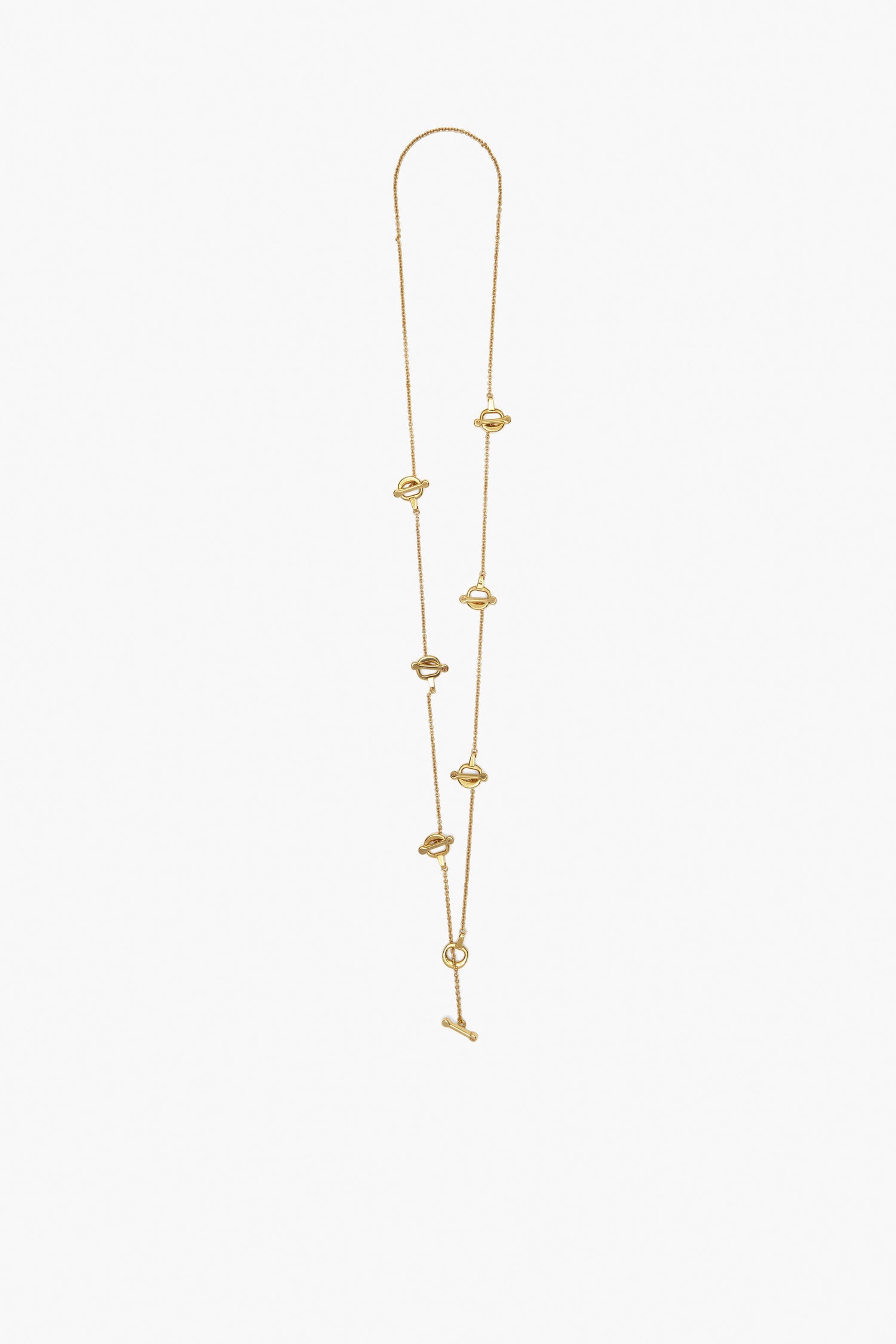 The Victoria Beckham Bridle Necklace in Gold is a handcrafted piece featuring multiple small knot designs, equestrian bridle charms, and a sleek toggle clasp.